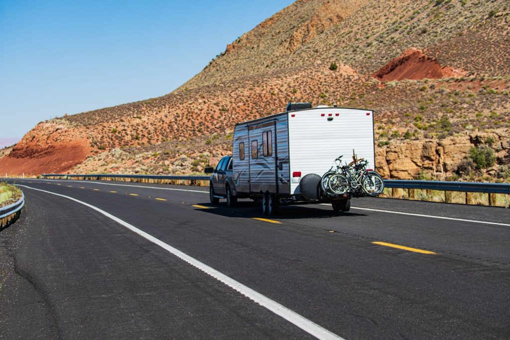 Truck pulling a travel trailer down the highway.